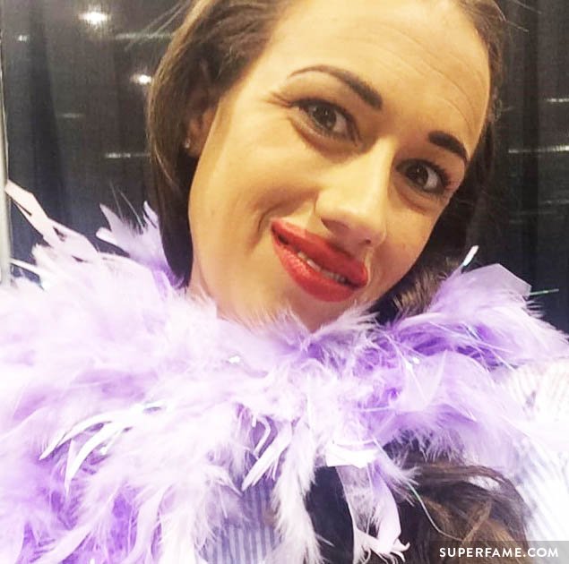 Miranda Sings dons purple feathers.