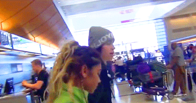 Nash and Taylor walk through the airport.
