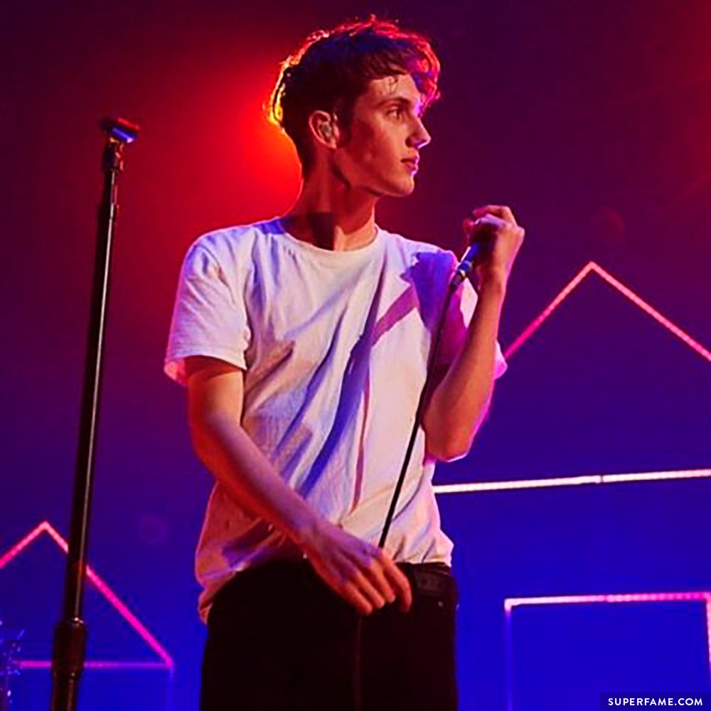 Troye performs live in a white t-shirt.