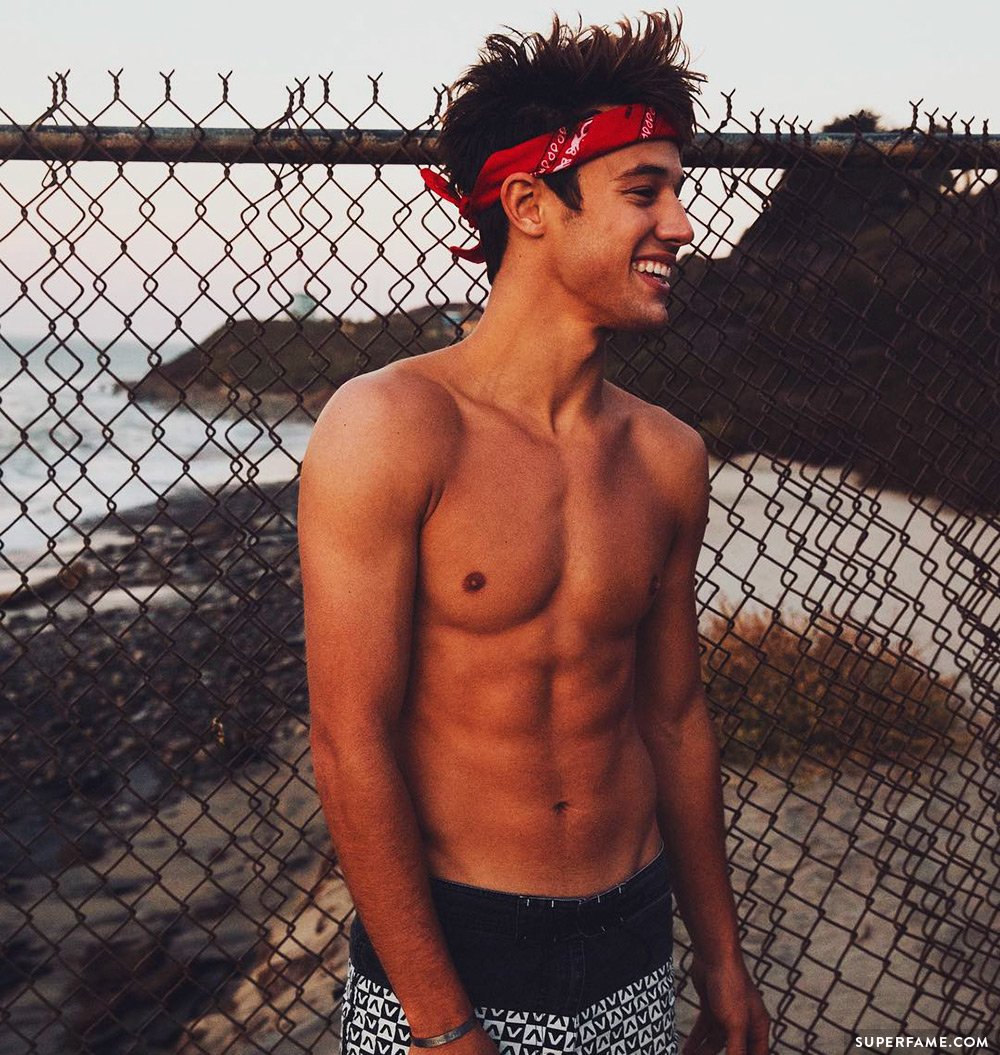 Cameron Dallas strips off next to a fence. 